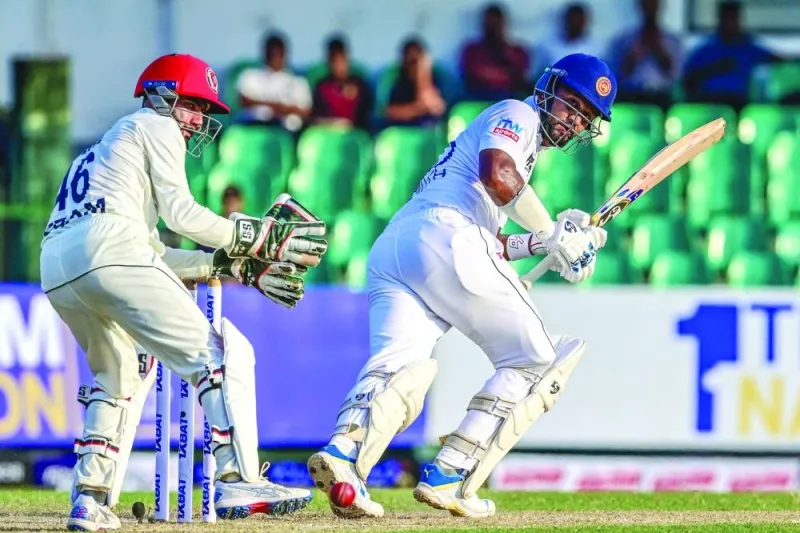 Sri Lanka’s Dimuth Karunaratne plays a shot as Afghanistan’s wicketkeeper Ikram Alikhil watches during the first day of the one-off Test in Colombo on Friday. (AFP)