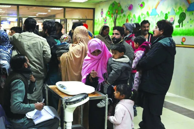 Parents wait with their children suffering from pneumonia, at the Children’s Hospital in Lahore.
