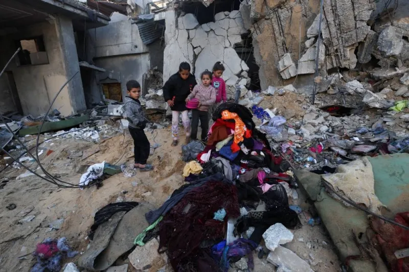 Palestinian children stand near a pile of clothes amidst rubble at the site of an Israeli strike in Rafah in the southern Gaza Strip on Saturday.