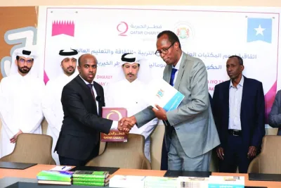 Dr. Mohamed Ahmed Sheir, director of the National Library of Somalia, and Abdulfattah Adam, head of the Somali branch of Qatar Charity, shake hands after signing the agreement. Dr. Mohamed Ahmed Sheir, director of the National Library of Somalia, and Abdulfattah Adam, head of the Somali branch of Qatar Charity, shake hands after signing the agreement.