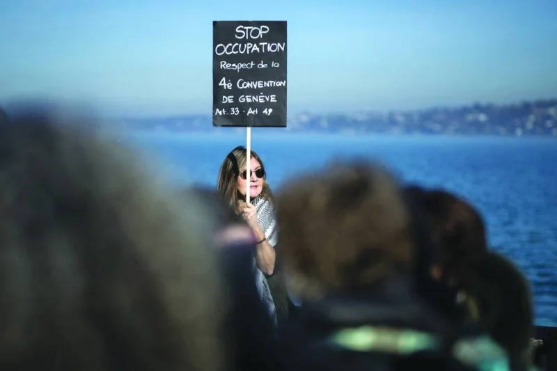 A woman holds a placard on the Geneva Convention during a demonstration in Geneva for a ceasefire in Gaza and in solidarity with the Palestinian people.