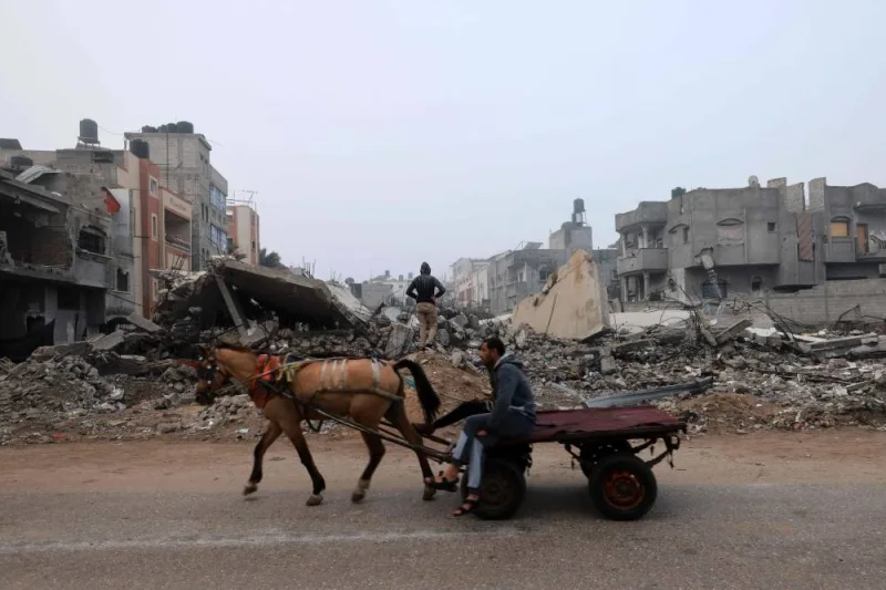 A man rides a horse-pulled cart along a street ravaged by Israeli bombing in Rafah on Friday. AFP