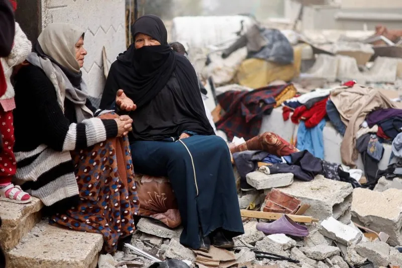 Palestinian women talk as they sit at the site of an Israeli strike on a house in Rafah on Friday. REUTERS