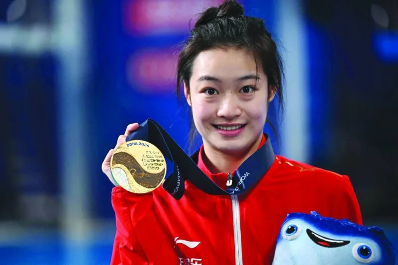 Gold medallist China’s Chang Yani poses on the women’s 3m springboard diving podium during the 2024 World Aquatics Championships at Hamad Aquatics Centre in Doha on Friday. (AFP)