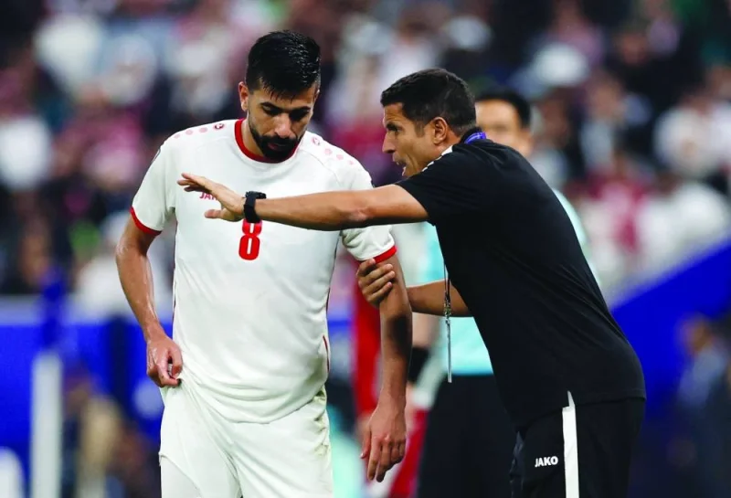 Jordan coach Hussein Ammouta (right) talks to midfielder Noor al-Rawabdeh during the AFC Asian Cup final against Qatar at the Lusail Stadium on Saturday. (Reuters)