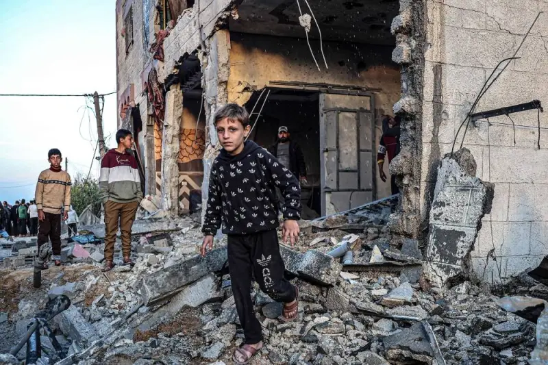 People walk through the rubble of a building heavily damaged by Israeli bombardment, in Rafah in the southern Gaza Strip on Sunday 