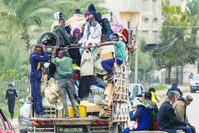 People evacuating from a tent camp ride in the back of a truck with belongings as they flee from Rafah in the southern Gaza Strip, yesterday.