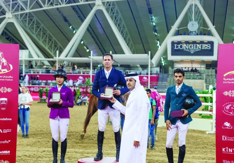 Brazil’s Santiago Lambre receives the winners’s trophy from FEI judge Nasser al-Hajri after his victory in the CSI5* against the clock 150cm class during the HH The Amir Sword International Equestrian Festival at Al Shaqab on Thursday. Thailand’s Janakabhorn 
Karunayadhaj and Saudi Arabia’s Khaled al-Mombty finished second and third respectively.