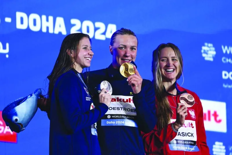 Gold medallist  Sweden’s Sarah Sjostrom (centre), silver medallist US’ Kate Douglass (left) and bronze medallist Poland’s Katarzyna Wasick pose on the podium of the women’s 50m freestyle event during the World Aquatics Championships – 2024 at Aspire Dome in Doha yesterday. (AFP)