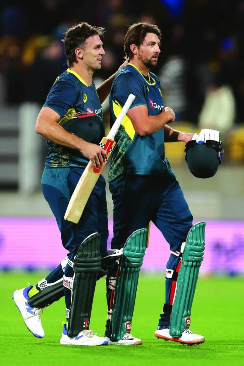Australia’s captain Mitchell Marsh (left) walks with teammate Tim David after winning the first T20I against New Zealand at Sky Stadium in Wellington on Wednesday. (AFP)