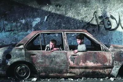 Children sit in a destroyed car in Rafah, Wednesday.