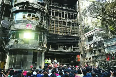 
People gather near the building as firefighters and forensic expert inspect the site in Dhaka yesterday. 