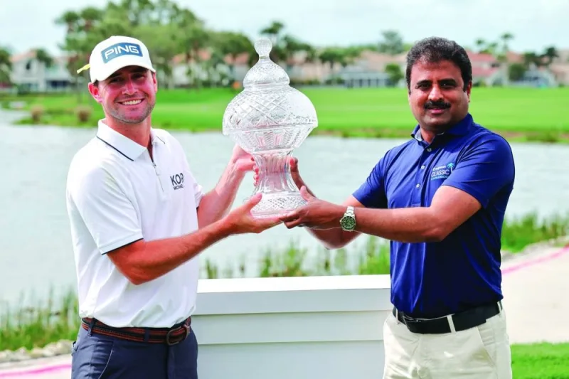 Austin Eckroat (left) is handed the winner’s trophy by the EVP and President of Cognizant Americas Surya Gummadi after winning the Cognizant Classic. (USA TODAY Sports)