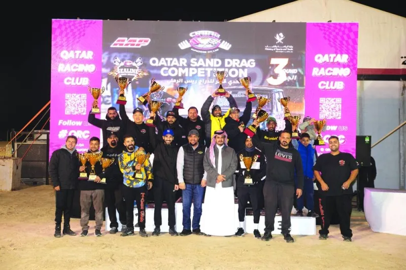
Winners of the third round of Sealine Qatar Sand Drag Competition celebrate with QRC director Sheikh Jabor bin Khalid al-Thani. 