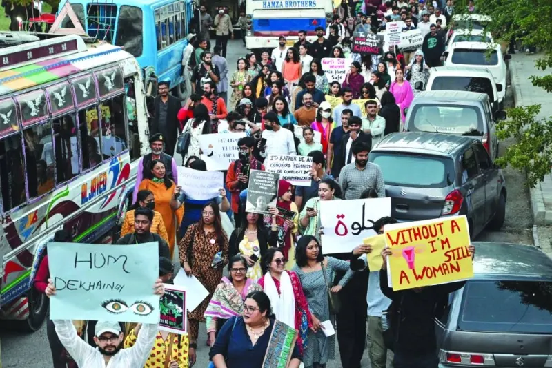 Women activists of Aurat March hold placards during a rally to mark the International Women's Day in Karachi.