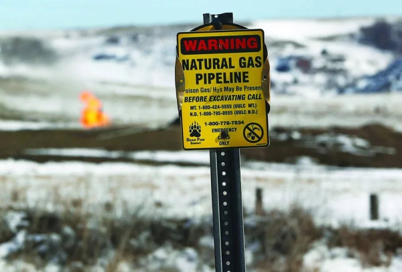 A warning sign for a natural gas pipeline is seen in front of natural gas flares at an oil pump site outside of Williston, North Dakota.  (Reuters)