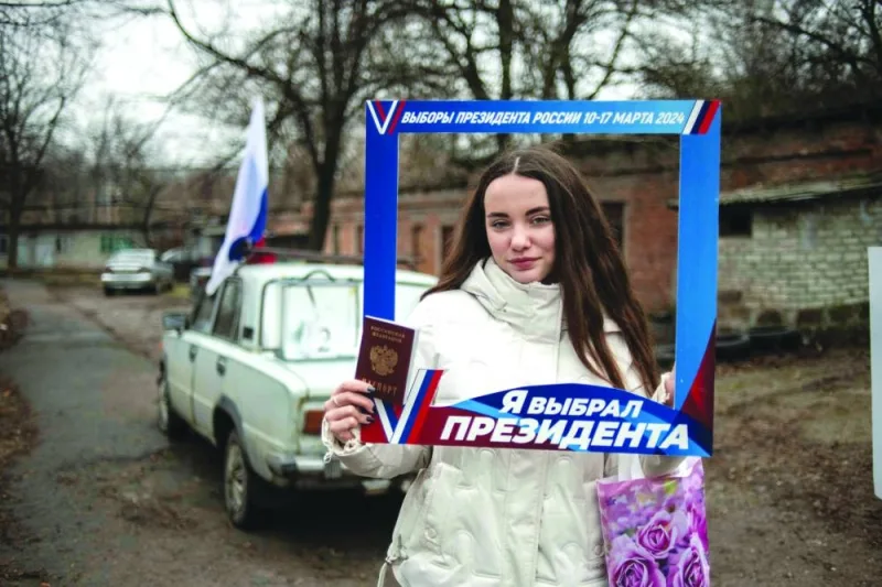 A woman poses after casting her ballot at a mobile polling station 
during early voting in Russia’s presidential election in Donetsk, Russian-controlled Ukraine. A woman poses after casting her ballot at a mobile polling station 
during early voting in Russia’s presidential election in Donetsk, Russian-controlled Ukraine.