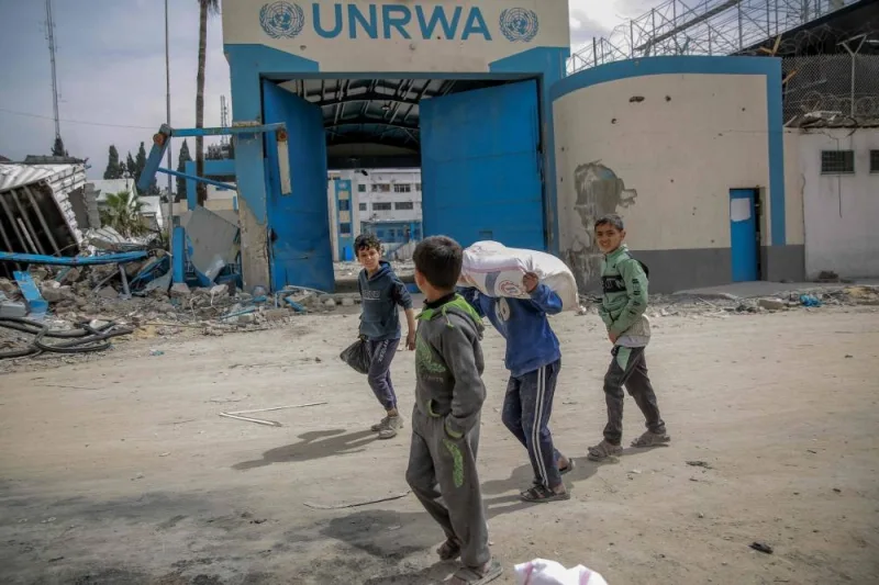 Children carry bags of flour after humanitarian aid was distributed in Gaza City on Sunday. AFP
