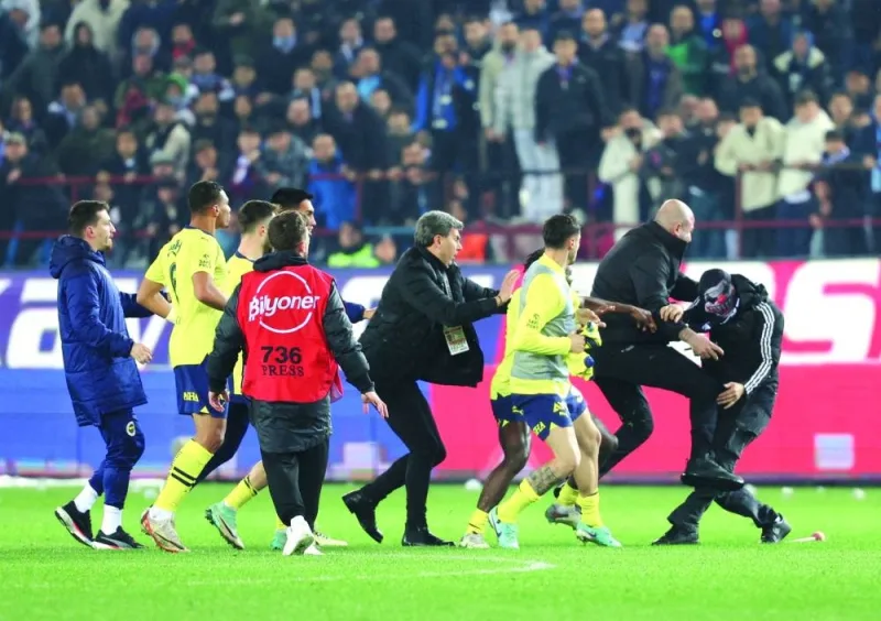 
A Trabzonspor fan invades the pitch and clashes with Fenerbahce players and security staff after the Super Lig match. (Reuters) 