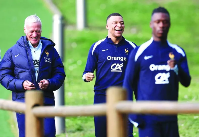 France’s head coach Didier Deschamps (left) shares a laugh with Kylian Mbappe before a training session as part of the team’s preparation for upcoming friendly in Clairefontaine-en-Yvelines on Thursday. (AFP)