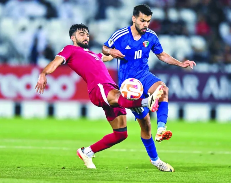
Qatar’s Tarek Salman (left) and Kuwait’s Faisal Zaid al-Harbi vie for the ball. 