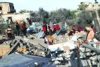 Palestinians assess the destruction of a house hit by Israeli bombardment in the northern part of Rafah in the southern Gaza Strip, yesterday, amid ongoing battles between Israel and the Hamas group.