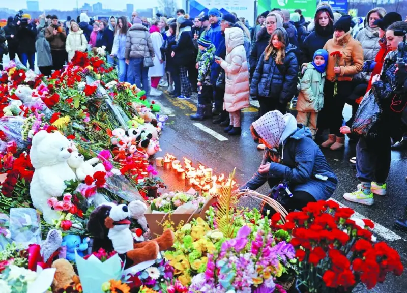 People gather at a makeshift memorial to the victims of a shooting attack set up outside the Crocus City Hall concert venue in the Moscow Region, Saturday.