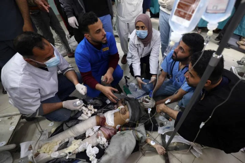 Medics provide urgent medical care to a child injured in Israeli bombardment, as she lies on the floor at the al-Najjar hospital in Rafah in the southern Gaza Strip on Sunday. AFP