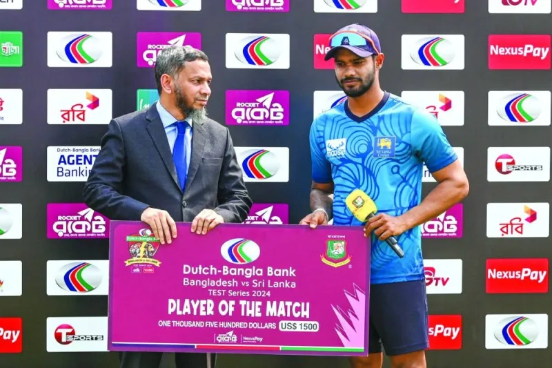 Sri Lanka’s captain Dhananjaya de Silva (right) is seen receiving the Man of the Match award at the end of the first Test against Bangladesh at the Sylhet International Cricket Stadium in Sylhet on Monday. (AFP)