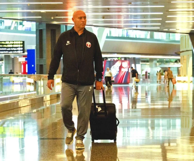 Qatar’s head coach Marquez Lopez (left) and his players arrive in Kuwait City on Monday, on the eve of their match against Kuwait.