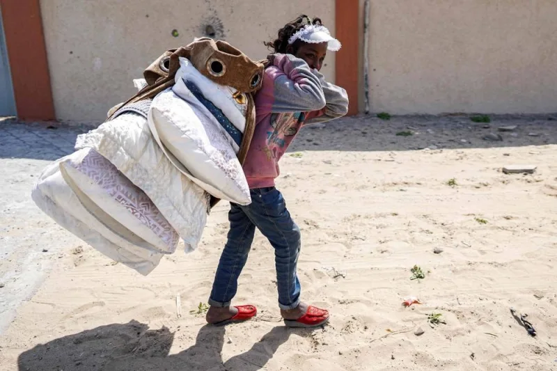 A girl walks carrying pillows as she and others evacuate from Gaza City on Monday. AFP
