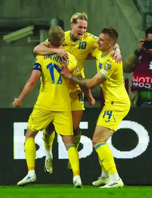 
Ukraine’s Mykhailo Mudryk (centre) celebrates with teammates Oleksandr Zinchenko and Volodymyr Brazhko after scoring against Iceland during the Euro 2024 qualifier play-off match in Wroclaw, Poland, on Tuesday. (Reuters) 