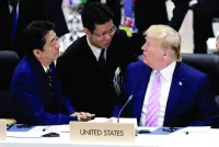 
Sunao Takao (centre) helps with translation as Japan’s then-prime minister Shinzo Abe and US president Donald Trump talk prior to a working lunch at the Group of 20 summit in Osaka, Japan, on June 28, 2019. (Reuters) 
