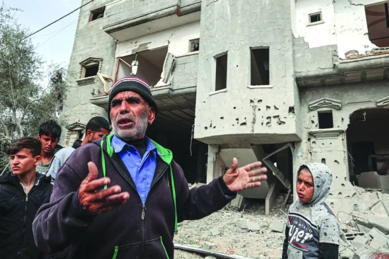Palestinians inspect the damage to a building after overnight Israeli bombardment in Rafah in the southern Gaza Strip Friday.