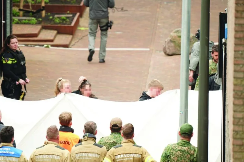 
Three hostages (faces obscured) leave after being held in the cafe Petticoat in Ede yesterday. (AFP) 