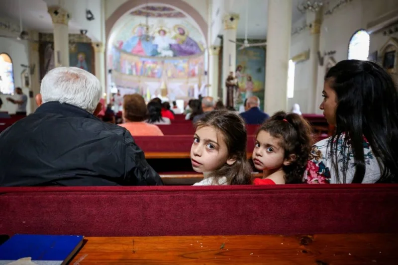 Children look on as Palestinian Christians attend an Easter mass at the Holy Family Church amid muted festivities in Gaza City on Sunday. REUTERS