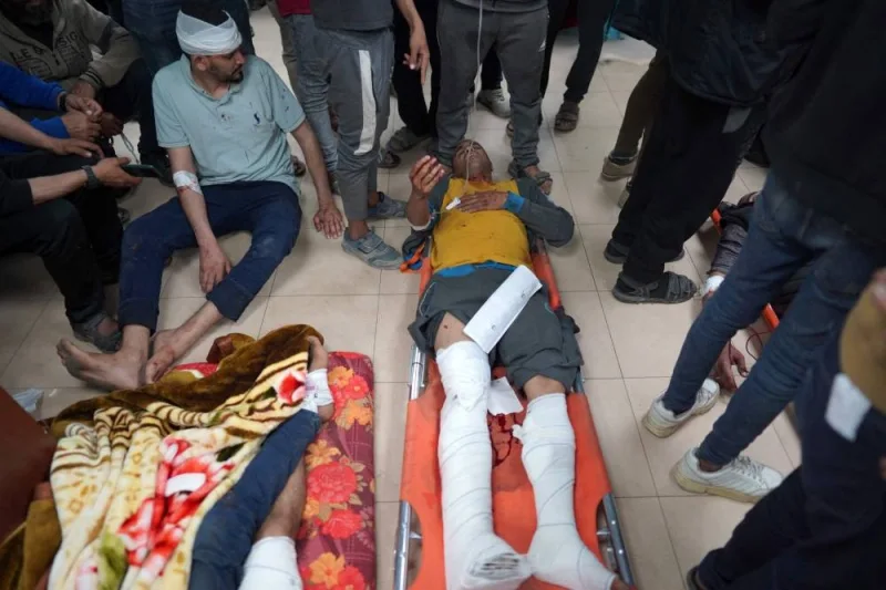 Injured Palestinian men lie on the floor at the Al-Aqsa Martyrs Hospital in Deir al-Balah in the central Gaza Strip, following Israel bombardment on Sunday. AFP
