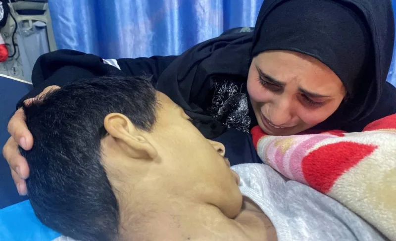 The mother of Palestinian boy Karam Qadadah, a hepatitis patient who was evacuated with his mother from Al-Shifa hospital during an Israeli raid, reacts next to his body after he died at Kamal Adwan hospital, in the northern Gaza Strip, on Saturday. REUTERS