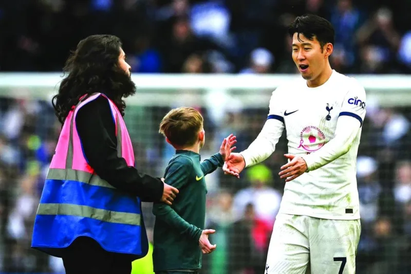 
Tottenham Hotspur’s Son Heung-Min greets a young pitch invader after the end of the Premier League match against Luton Town. (AFP) 