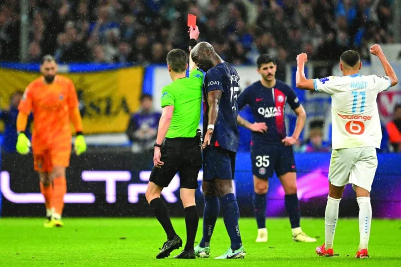 
French referee Benoit Bastien (left) gives a red card to PSG defender Lucas Beraldo during the French Ligue 1 match against Marseille. (AFP) 