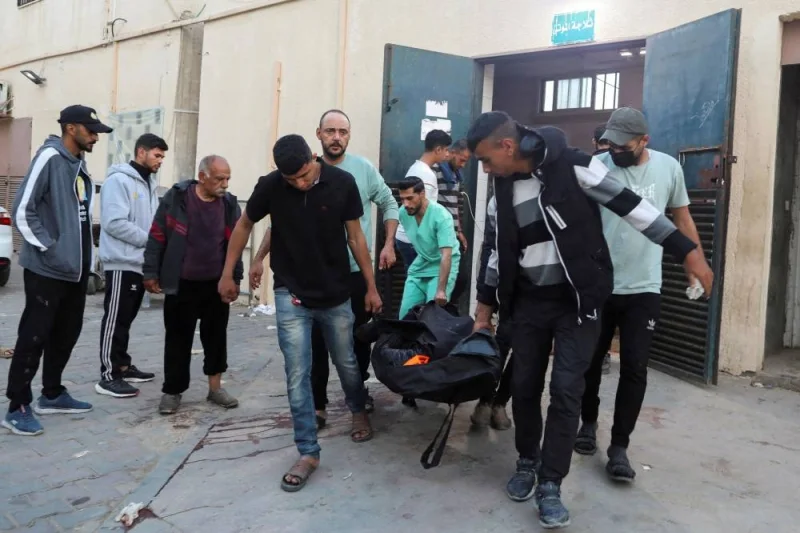 Palestinians carry the body of a foreign employee from the World Central Kitchen (WCK), who was killed with other fellow workers in an Israeli airstrike at a hospital in Deir Al-Balah, in the central Gaza, Tuesday. REUTERS