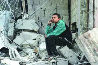A Palestinian boy sits amid the rubble of a destroyed house in the southern Gaza Strip city of Rafah, yesterday, following overnight Israeli bombardment of the area amid the ongoing conflict.