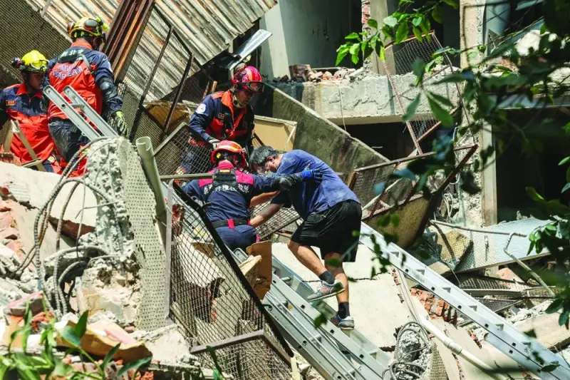 Emergency workers assisting a survivor after he was rescued from a damaged building in New Taipei City