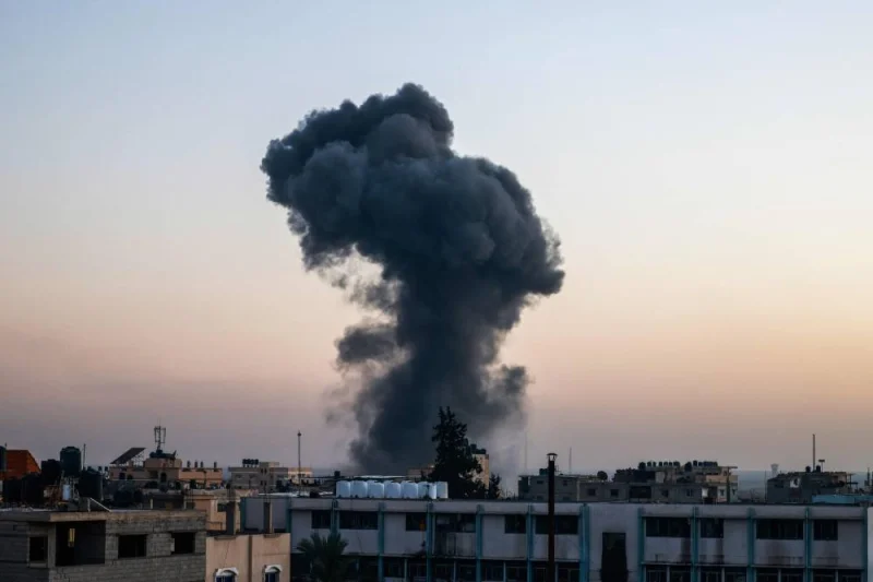 A billow of smoke rises over buildings after an Israeli strike in Rafah, southern Gaza Strip, on Thursday. AFP
