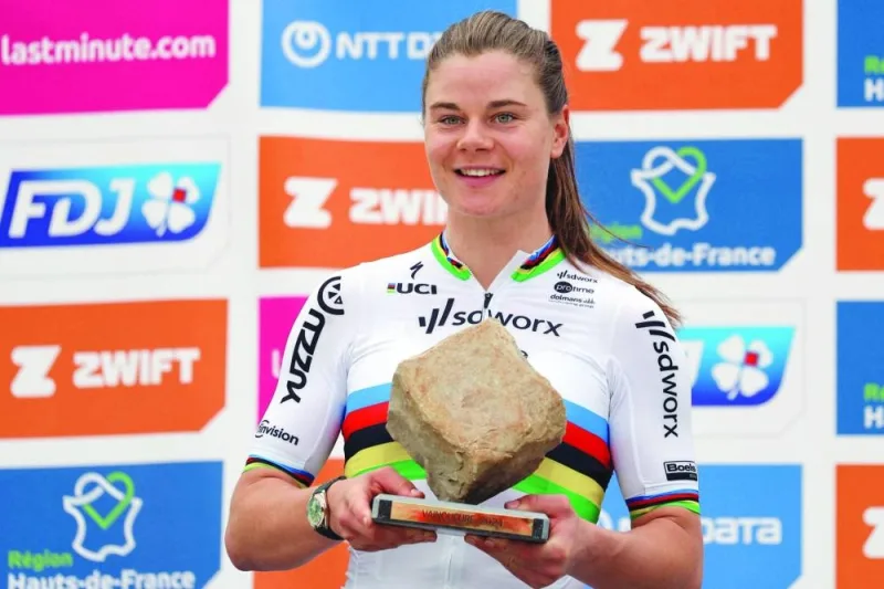 Lotte Kopecky celebrates on the podium with the trophy after winning the fourth edition of the Paris-Roubaix one-day classic cycling race on Saturday. (AFP)