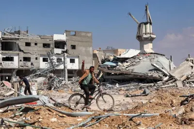 A man gestures as he rides a bicycle along a heavily damaged road past destroyed buildings in Khan Yunis on Sunday after Israel pulled its ground forces out of the southern Gaza Strip, six months into the devastating war. AFP