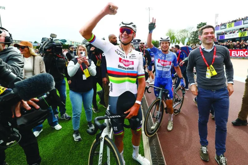 Alpecin - Deceuninck team&#039;s Dutch rider Mathieu Van Der Poel celebrates his victory with teammate Belgian rider Jasper Philipsen (second right) after winning the 121st edition of the Paris-Roubaix one-day classic cycling race, 260km between Compiegne and Roubaix, northern France, yesterday. (AFP)