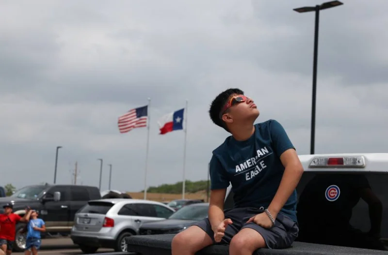A boy looks up as people gather to view a total solar eclipse in Eagle Pass, Texas.