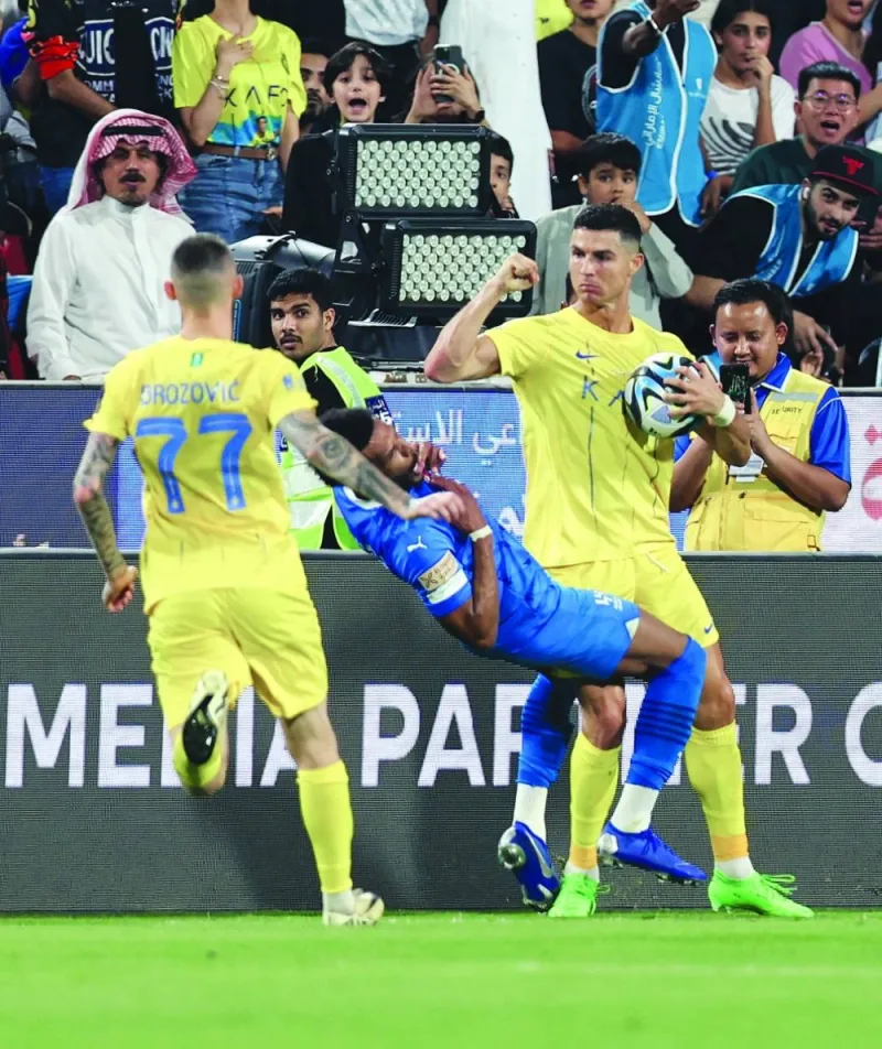 Al Nassr’s Cristiano Ronaldo (right) clashes with Al Hilal’s Ali al-Bulayhi before being shown a red card during the  Saudi Super Cup semi-final in Abu Dhabi on Monday. (Reuters)