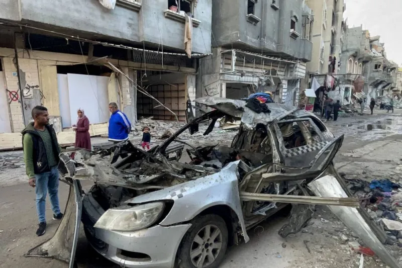 Onlookers check the car in which three sons of Hamas leader Ismail Haniyeh were reportedly killed in an Israeli air strike in al-Shati camp, west of Gaza City, Wednesday.